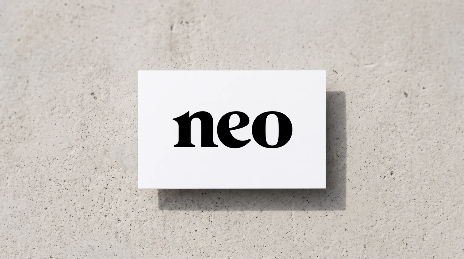 The Neo Financial logo on a matte white card resting on a pale poured-concrete surface.