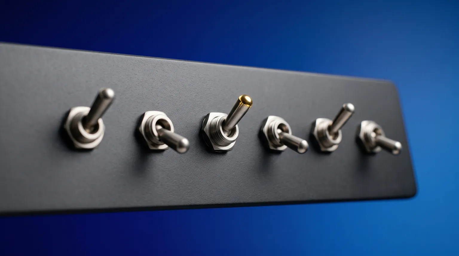 A row of six brushed-metal toggle switches on a matte panel, three flipped up and three flipped down.