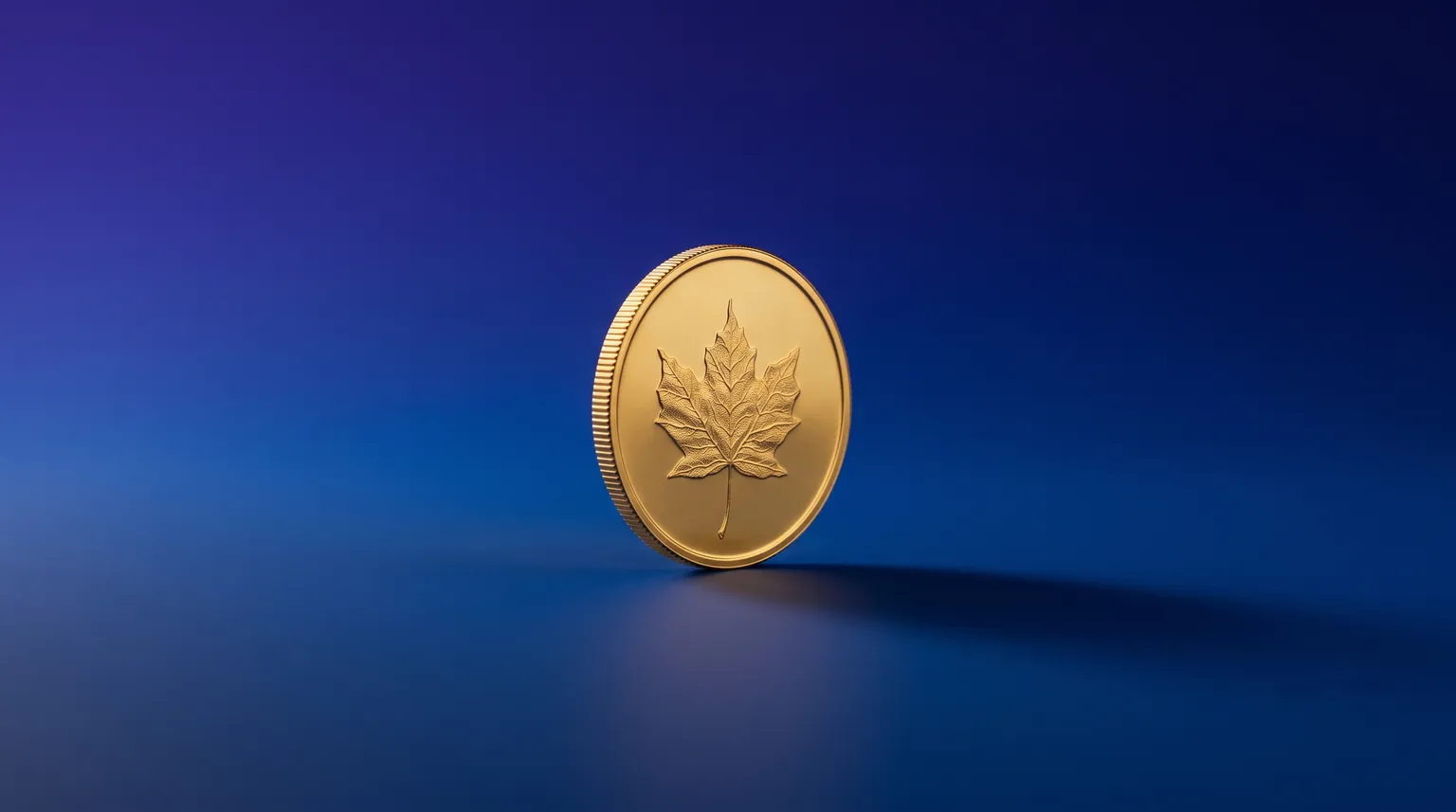 A single gold coin embossed with a maple leaf resting on a deep blue surface, catching soft light.